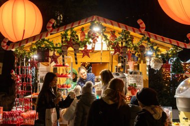 Lugano, İsviçre - 23 Aralık 2024: Ziyaretçilere sıcak içecek ve tatlı ikram eden bir Noel Pazarı