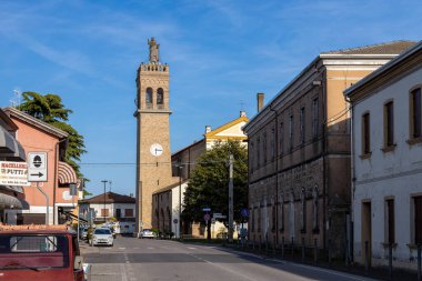 Codevgo, Padua, İtalya - 27 Nisan 2025: Tarihi kent merkezinde çan kulesi, kilise ve geleneksel binalarla sokak manzarası.