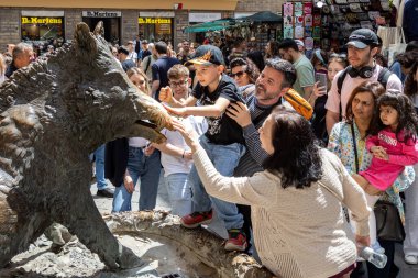 Floransa, İtalya - 10 Mayıs 2025: Mercato Nuovo 'daki ikonik bronz domuz heykeli Il Porcellino' nun burnunu ovuşturan turistler ve çocuklar