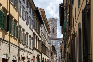 Floransa, İtalya - 10 Mayıs 2025: Dar bir sokaktaki tarihi binalar tarafından çerçevelenmiş Giottos Bell Tower manzarası