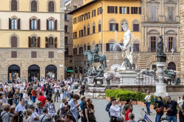 Florence, Italy - May 10th, 2025: Tourists gather around the Fountain of Neptune and the statue of Cosimo I in Piazza della Signoria