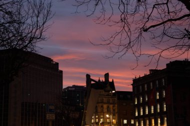 Gün batımında kentsel yaşamın canlı bir tasviri, renkli akşam gökyüzünün doğal güzelliği ile hareketli şehir çevresi arasındaki dinamik zıtlığı gözler önüne seriyor. Görüntüler çok canlı.