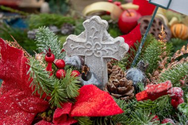 Zengin yeşillikler, parlak kırmızı fiyonklar, kozalaklar ve mevsimsel aksanlar içeren el yapımı tatil düzenlemelerinin canlı bir gösterisi. Kutsal çilekler ve donmuş yapraklar gibi. Tasarımlarda çelenkler var.