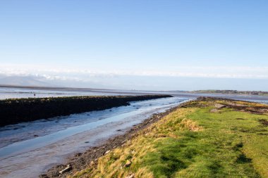 Tralee 'deki su kanalı, Kerry ilçesi, İrlanda. Yüksek kalite fotoğraf. Güneşli hava mavi suyu doygun hale getiriyor. Nehir, okyanus, yürüyüş yolu ve evlerle doğa manzarası çok güzel. Dağlar ve beyaz