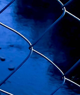 Bir dağ nehrinin görülebildiği bir güneş ağı çitinin yakın çekimi..