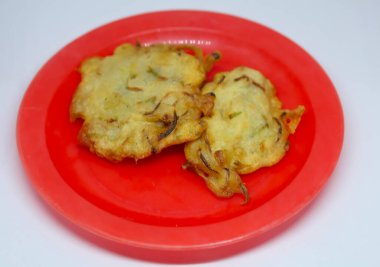 Kızarmış bakwan yemeği kırmızı tabakta servis edilir.