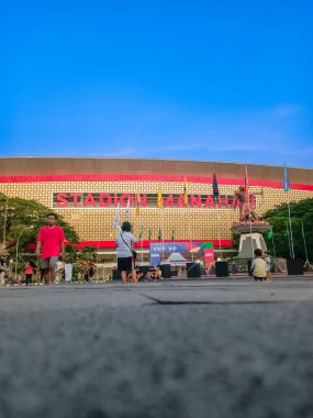 Indonesia, Solo - October 10, 2024: The magnificent Manahan stadium field with a blue sky background, a place to play football with various fierce competitions is in the city of Solo. clipart