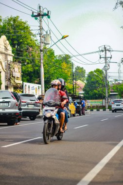 Endonezya, Surakarta - 16 Kasım 2024: Asyalı bir adam karısıyla birlikte motosiklet sürüyor
