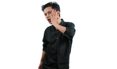 Asyalı bir adam kendi yanağını tokatlıyor.