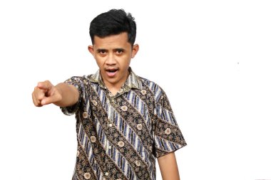 Batik giysiler giymiş Asyalı bir adam, beyaz arka planda soyutlanmış, ciddi bir ifadeyle öne bakıyor.