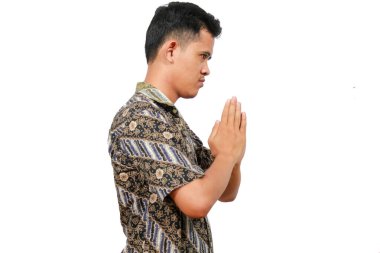 Batik giysili yakışıklı Asyalı adam izole edilmiş beyaz arka planda jest yapıyor.