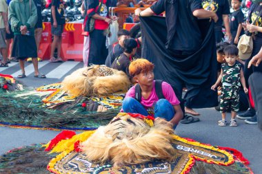 Endonezya, Solo - 22 Aralık 2024: Ponorogo reog dansçıları gösteriden önce barongan 'ı kontrol ediyorlar
