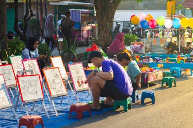 Endonezya, Solo - 22 Aralık 2024: Asyalı adam çocuğuyla resim yapmakla meşgul