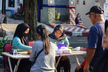 Endonezya, Solo - 22 Aralık 2024: Doktorlar yol kenarında ücretsiz sağlık kontrolleri yapıyorlar