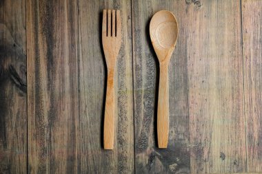Tahta arka planda soyut ahşap çatal ve kaşık izole