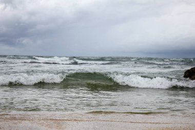 Güzel deniz manzarası, dalgalar beyaz gökyüzü arka planına karşı.