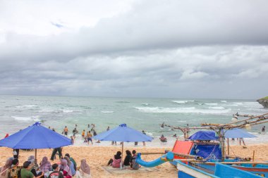 Endonezya, Yogyakarta - 12 Ocak 2025: bir grup insan sahilde tatilin tadını çıkarıyor