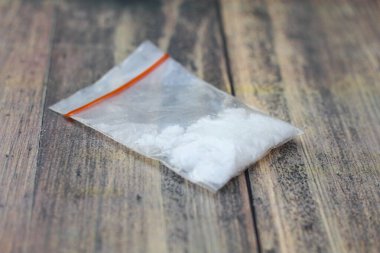 Küçük şeffaf plastiğe sarılmış tuzla karıştırılmış uyuşturucu tozu.