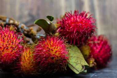 Siyah bir masada bir demet taze Nephelyum Lappaceum meyvesi.