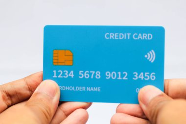 Asyalı adam kredi kartını beyaz arka planda tutuyor, iş konsepti