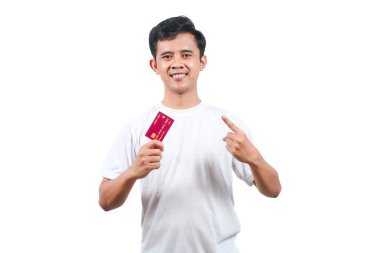 Beyaz tişört giyen Asyalı bir adam beyaz arka planda izole edilmiş ve kredi kartı gösteriyor.