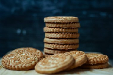 Tahta bir tahtanın üzerindeki lezzetli badem bisküvileri izole edilmiş koyu arkaplan