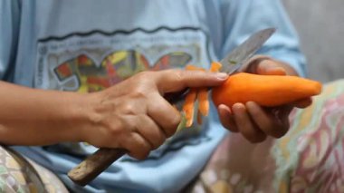 Bıçakla havuç derisini yüzme işlemi.