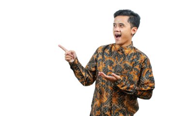 Şok olmuş Asyalı adam uzun kollu batik gömlek giyiyor boş odaya yan bakıyor, beyaz arka planda izole edilmiş.