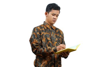 Batik tişört giyen genç öğrenciler, öğretim görevlisinin öğrettiği bilgileri not alıyorlar.