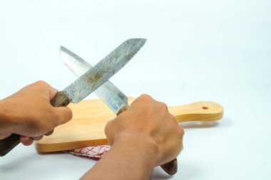 Asyalı bir adamın ahşap tahtanın önünde bıçağı tutması, yemek hazırlığı.