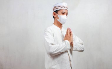 Ramazan kutlamalarıyla maskeli Asyalı Müslüman bir adam konukları selamlıyor