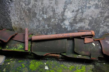 Beton duvarın yanında eski paslı bir pompa