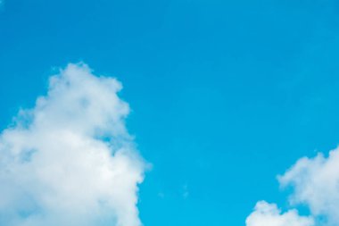 Mavi gökyüzü ve parlak bulutlar. Güneş tarafından vurgulanan gökyüzü çarpıcı bir görüntü sergiliyor, mükemmel bir kombinasyon.