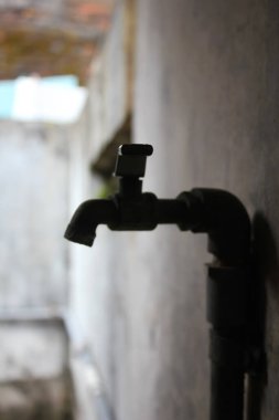 Kapalı su musluğu koyu gölge bokeh arkaplanı