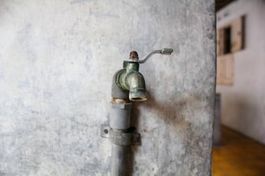 Kapalı su musluğu beton duvara bağlı.