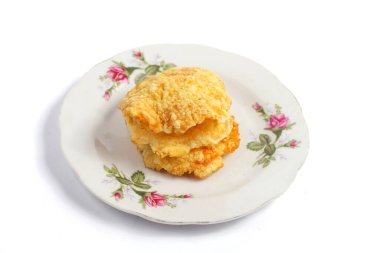 Beyaz arkaplanda izole edilmiş bir tabakta üç tatlı kraker (emping melinjo)