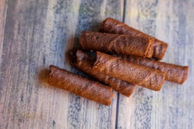 Tahta arka planda izole edilmiş bir avuç lezzetli çikolata astarı.