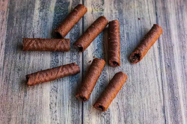 Tahta arka planda izole edilmiş bir avuç lezzetli çikolata astarı.