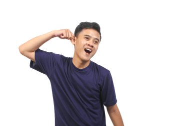 Asyalı bir adam mutlu bir ifade sergilerken kulağını tutuyor. Beyaz arka planda izole edilmiş.