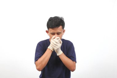 Lastik eldiven takan Asyalı adam kötü bir hastalığa yakalanmış. Sağlık konsepti.