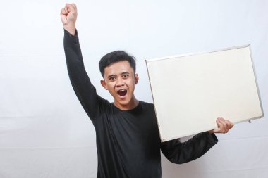 Siyah tişört giyen Asyalı bir adam beyaz arka planda protesto işareti taşıyor.