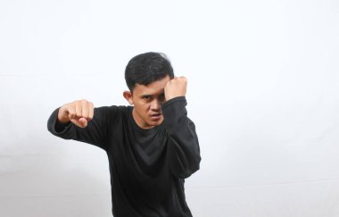 Asyalı adam savunma pozisyonu alıyor ve sonra sol eliyle sert bir yumruk atıyor.