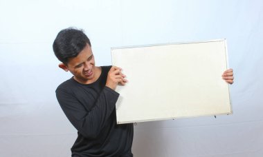 Siyah tişört giyen Asyalı bir adam beyaz arka planda protesto işareti taşıyor.