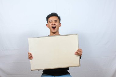 Siyah tişört giyen Asyalı bir adam beyaz arka planda protesto işareti taşıyor.