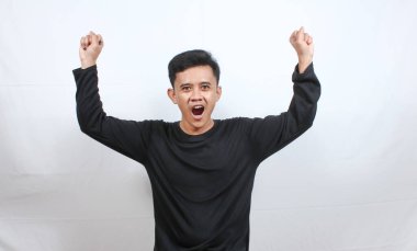 Asyalı bir adamın portresi protesto işareti yapıyor. Yumruğunu kaldırıyor, beyaz arka planı soyutluyor.