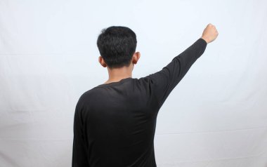 Asyalı bir adamın portresi protesto işareti yapıyor. Yumruğunu kaldırıyor, beyaz arka planı soyutluyor.