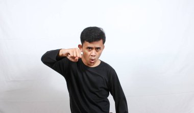 Asyalı uzun kollu siyah gömlek giyen adam düşmana yandan yumruk atıyor.