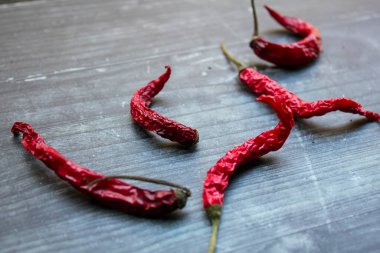 Siyah beyaz bir panoda kurutulmuş biberler.