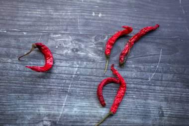 Siyah beyaz bir panoda kurutulmuş biberler.