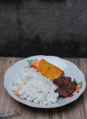 Geleneksel lezzetli gudeg pilavı ve yanında da cam tabakta servis edilen mayonez dolu sosis.
